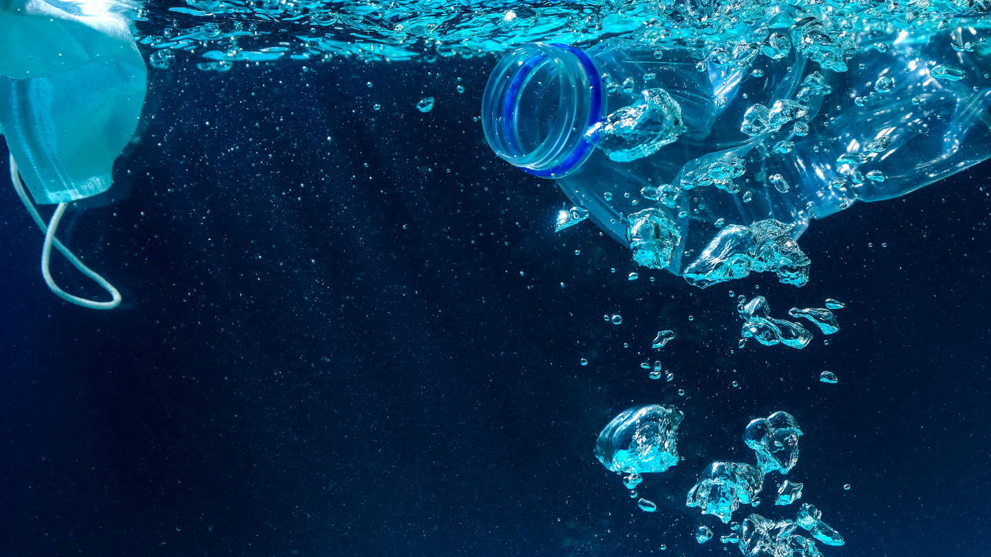 Plastic bottles and fishing nets floating among ocean waves